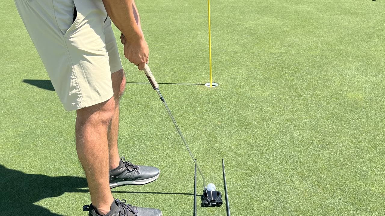 Alignment stick drill paired with an AimPutt bar to train stroke path and face square